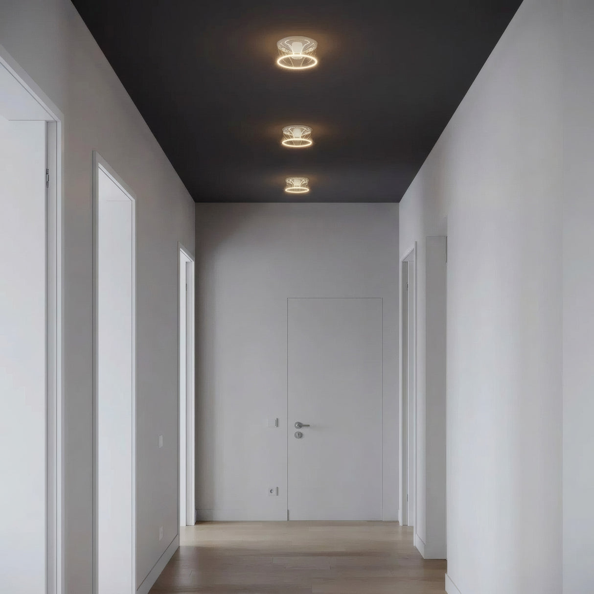 Three E27 LED donut bulbs in clear glass in a row on the ceiling of a pared-back hallway
