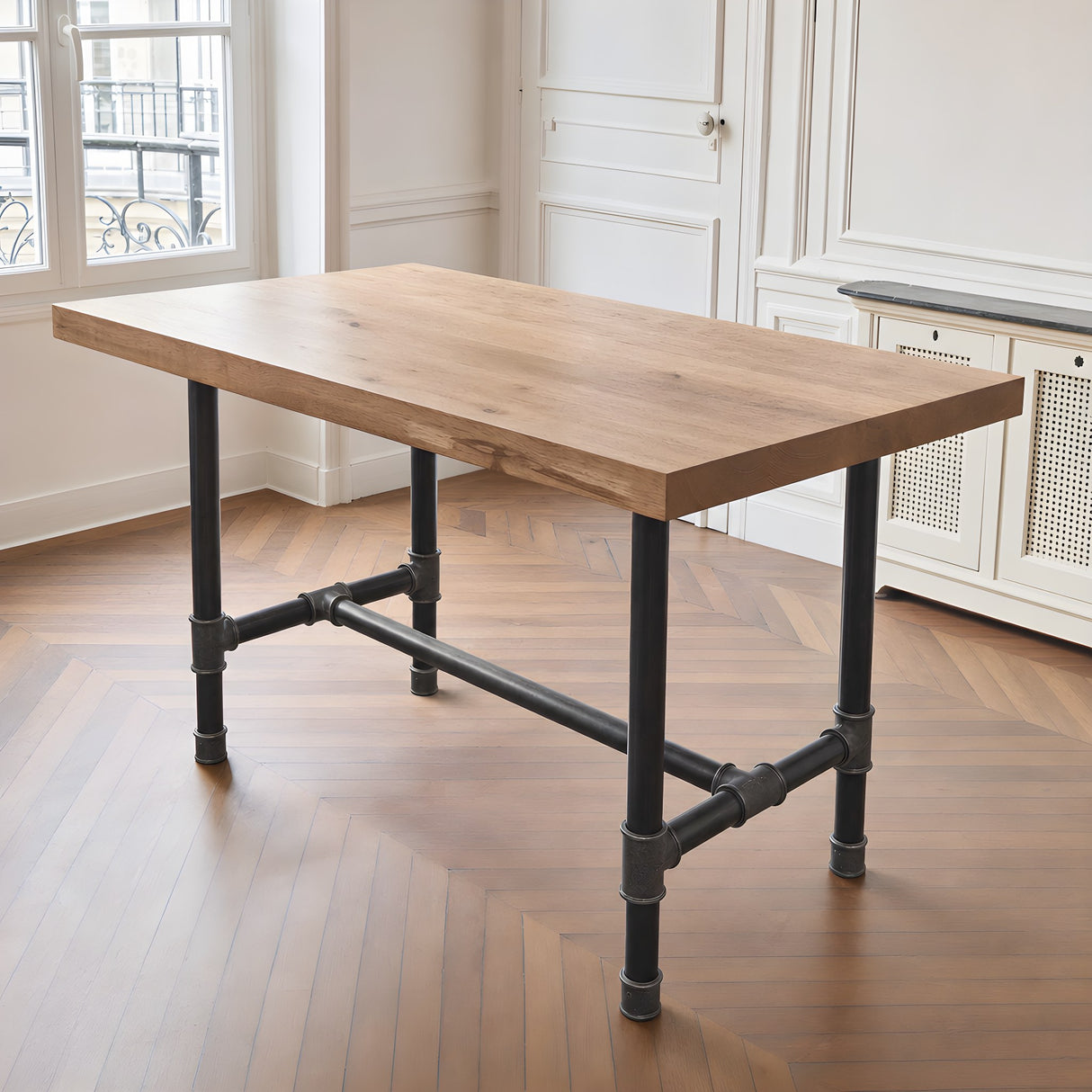 H-frame dining table base, cast iron and varnished steel Ø 42 mm, shown in a room under a thick solid oak tabletop