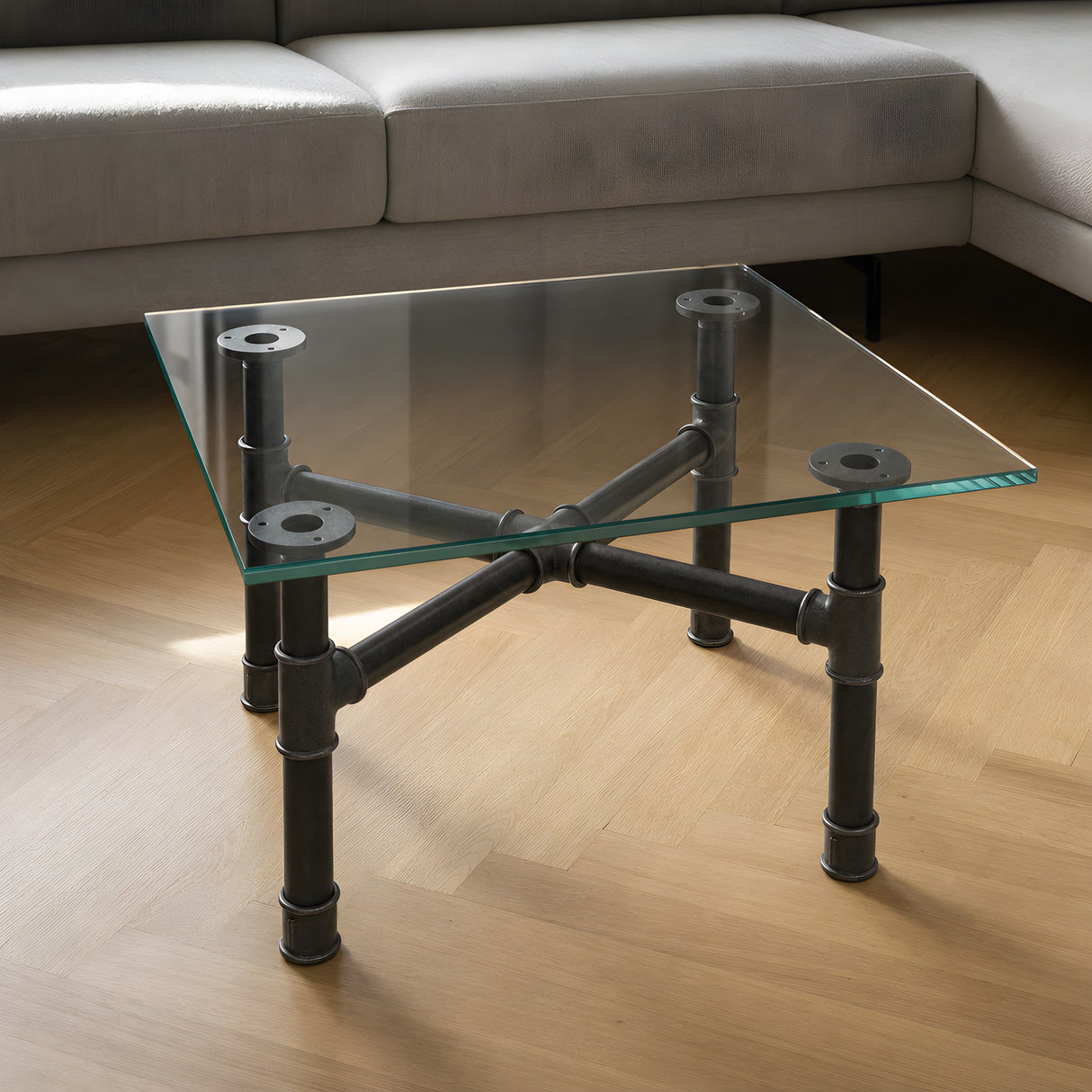 Cross-leg coffee table base, cast iron and varnished steel Ø 34 mm, shown in a room under a tempered glass tabletop