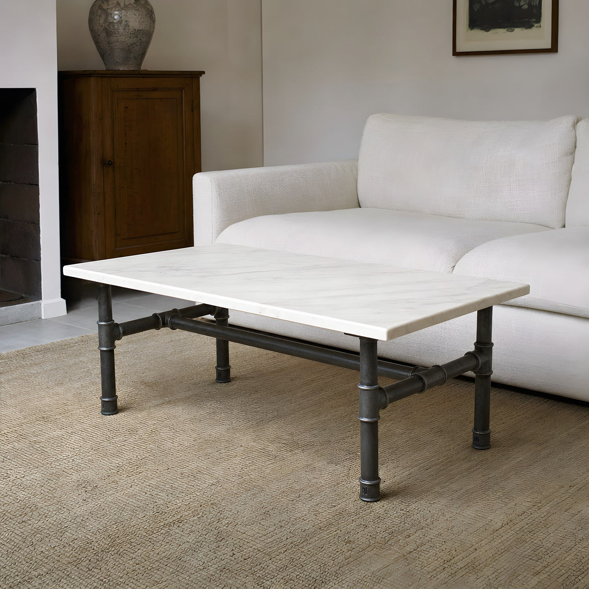 H-frame coffee table base, cast iron and varnished steel Ø 42 mm, shown in a room under a white marble tabletop