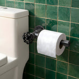 Black cast iron toilet paper holder with handwheel, mounted on a green zellige tile wall next to the toilet