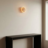 E27 LED donut bulb in smoked glass, Ø 195 mm, lit as a wall light in a pared-back living room