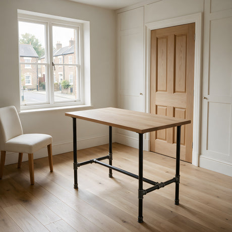 H-frame dining table base, cast iron and varnished steel Ø 27 mm, shown in a room under a light solid oak tabletop