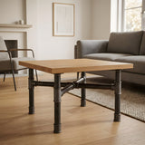 Cross-leg coffee table base, cast iron and varnished steel Ø 34 mm, shown in a room under a light solid oak tabletop