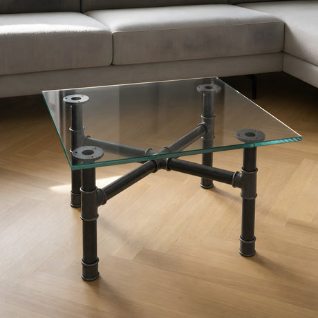 Cross-leg coffee table base, cast iron and varnished steel Ø 34 mm, shown in a room under a tempered glass tabletop