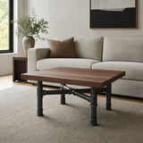 Cross-leg coffee table base, cast iron and varnished steel Ø 42 mm, shown in a room under a solid walnut tabletop