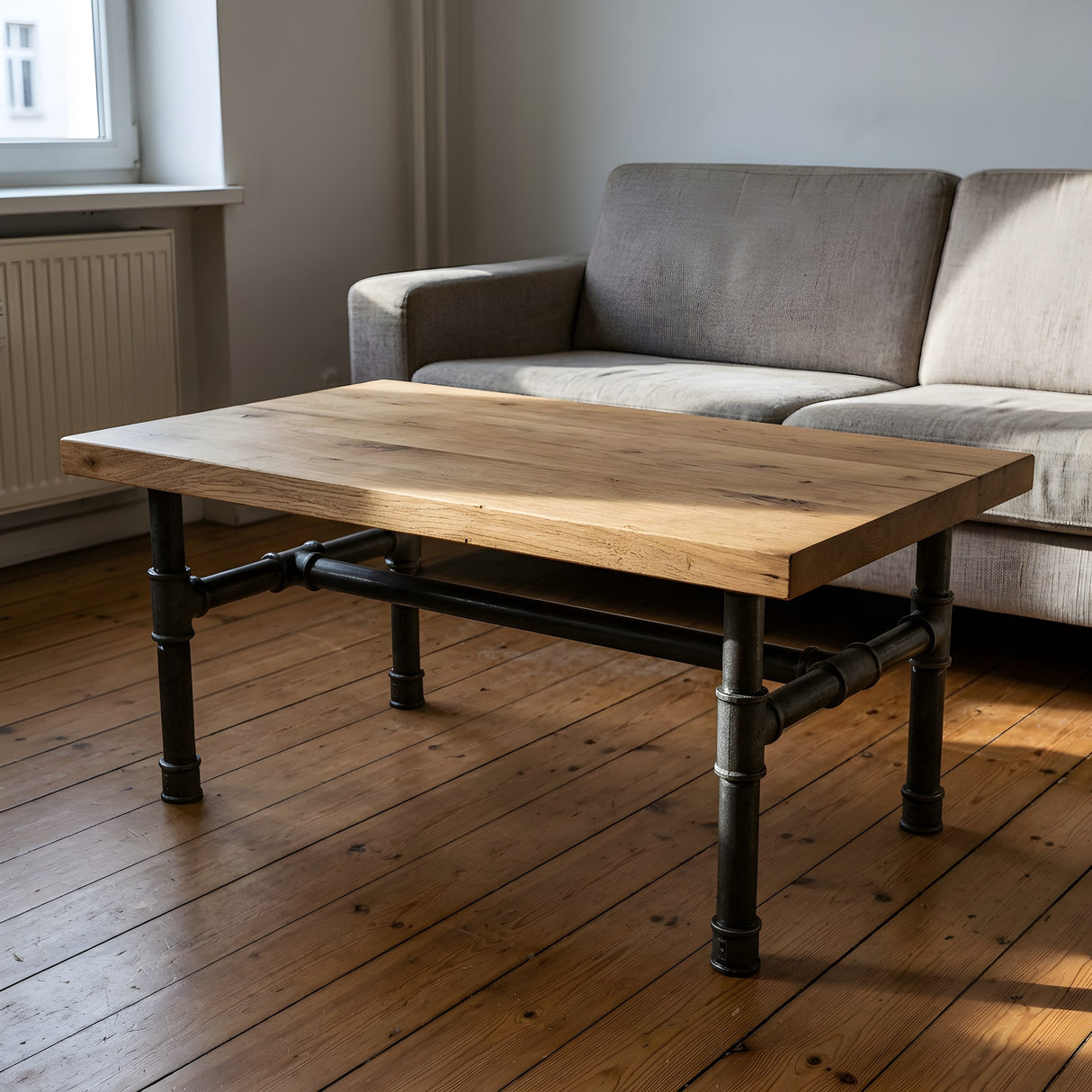 H-frame coffee table base, cast iron and varnished steel Ø 42 mm, shown in a room under a thick solid oak tabletop
