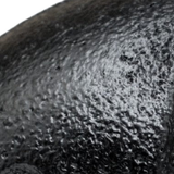 Close-up of the matte, grainy black paint on a cast iron fitting